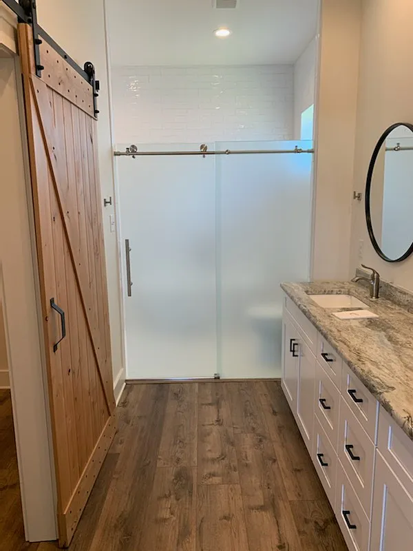 Frameless glass shower door with white frost privacy film in modern bathroom